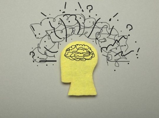 yellow silhouette of a person's head with a scribbled brain and scribbled thoughts on the outside