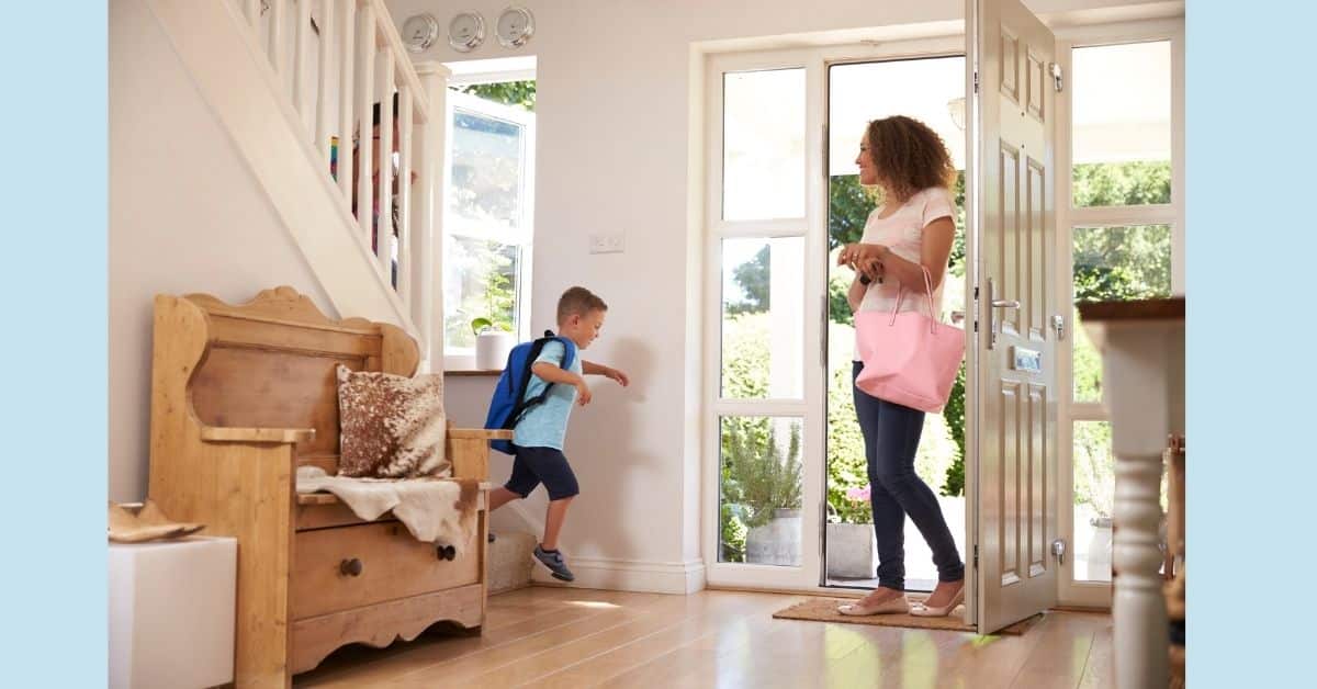 Kid wearing a backpack walks towards front door to meet his mom