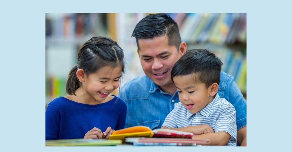 A dad reading a book with two kids